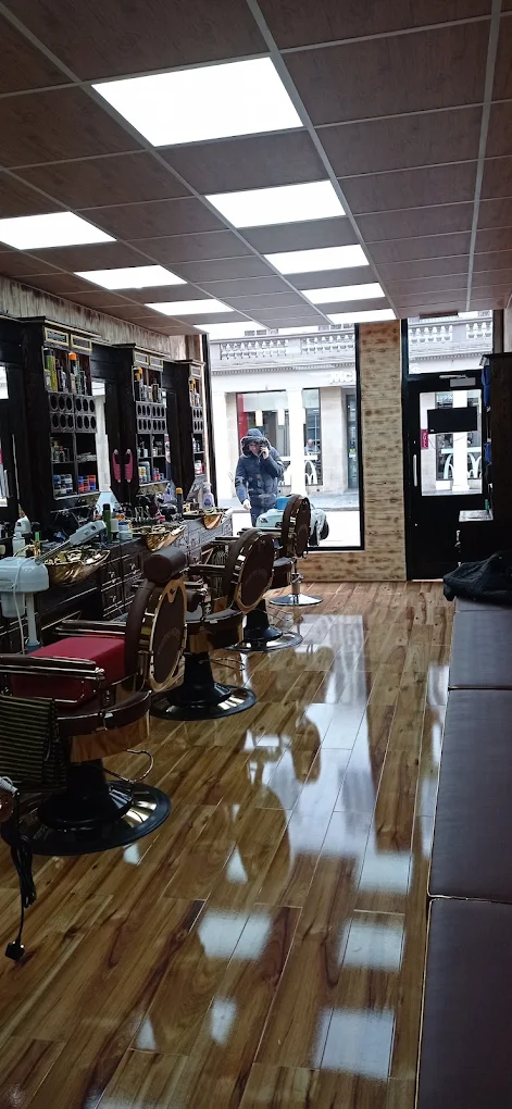 Completed timber-clad barbershop interior with polished wood floor and brass barber chairs — a fit-out by Afsin Services.