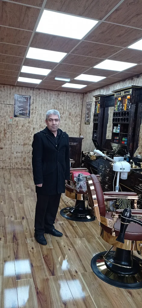 Owner standing inside the completed timber-clad barbershop with brass chairs.